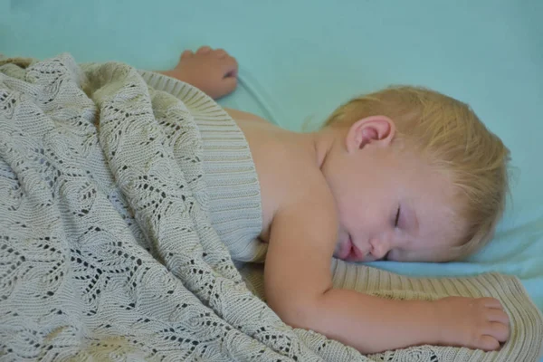 baby sleeping and knitted blanket