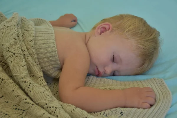 baby sleeping and knitted blanket