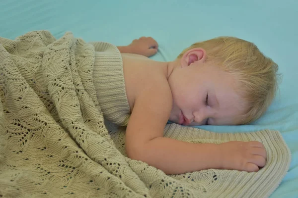 baby sleeping and knitted blanket