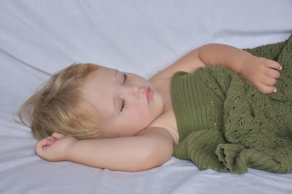 baby sleeping and knitted blanket