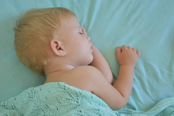 baby sleeping and knitted blanket