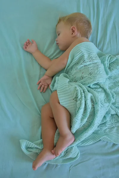 baby sleeping and knitted blanket