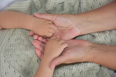 Selective focus of mother holding hands with child