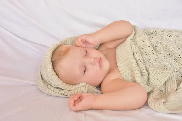 baby sleeping and knitted blanket