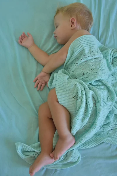 baby sleeping and knitted blanket