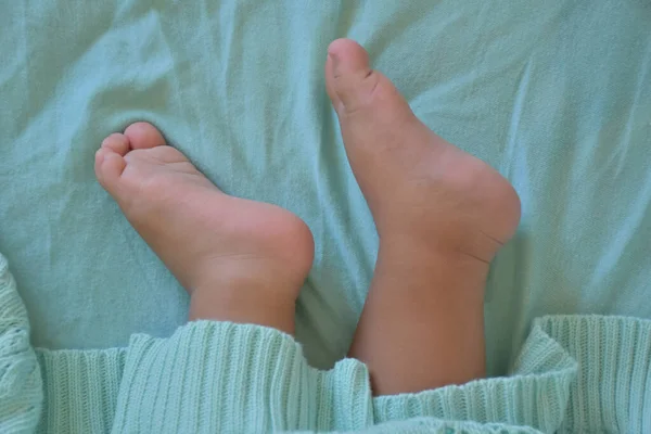 Selective Focus Barefoot Child Relaxing Covered Mint Colored Knit Fabric — 스톡 사진