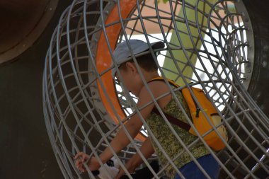 Small boy wearing cap playing in net ball on playground