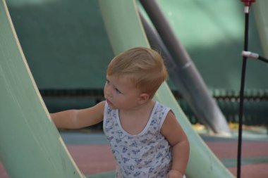 Cute toddler boy having fun outdoors on the playground