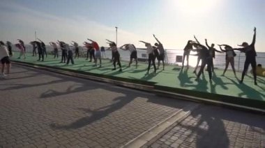 Eylül 2021 - Odessa, Ukrayna. Deniz kenarı eğitimi. Genç sporculardan oluşan büyük bir grup spor salonunda antrenman yapıyor, sabah iskelede ısınma egzersizleri yapıyor, çekim takibi yapıyorlar.