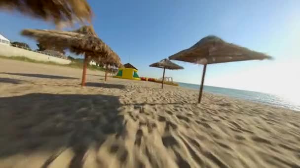 FPV carreras Drone Shot Flyby en la playa del Mar Negro en Griborka, cerca de Odessa. Beach Resort con sombrillas de paja — Vídeo de stock