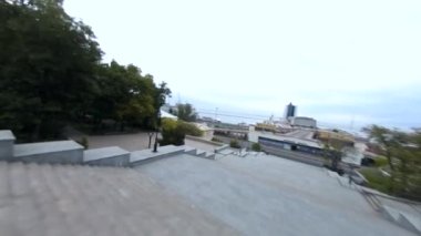 Ukrayna, Odessa 'daki tarihi şehir merkezinin FPV insansız hava aracı görüntüsü. Uçan İHA Sarı yapraklı ağaçlarla parkta uçuyor.