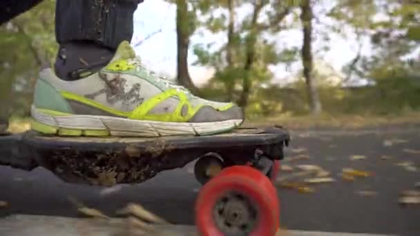 Close Up Shot Electro Skate Riding. Outono com folhas amarelas caindo e asfalto molhado. Leisure Drive — Vídeo de Stock