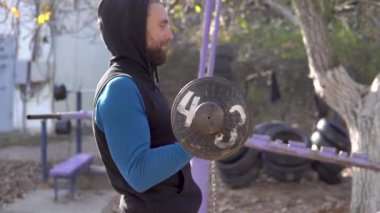 Güz 'de Açık Hava Spor Salonu' nda kol kaslarını el yapımı demir halterle çalıştıran Gri Saçlı Güçlü Adam. Halk Sokağı Eğitim Kutusu. Şehir sokak çalışması.