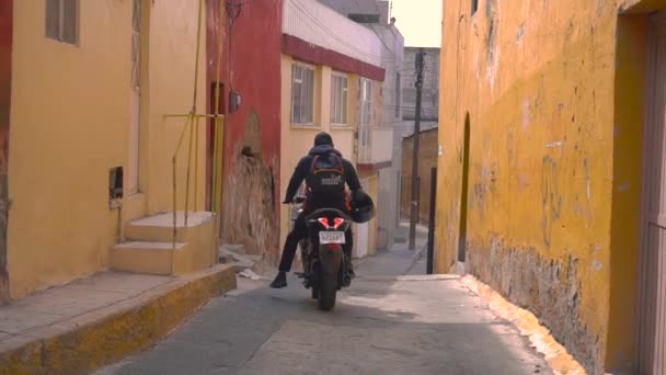 Человек на мотоцикле на узких улицах Пачуки, штат Идальго, Мексика — стоковое видео