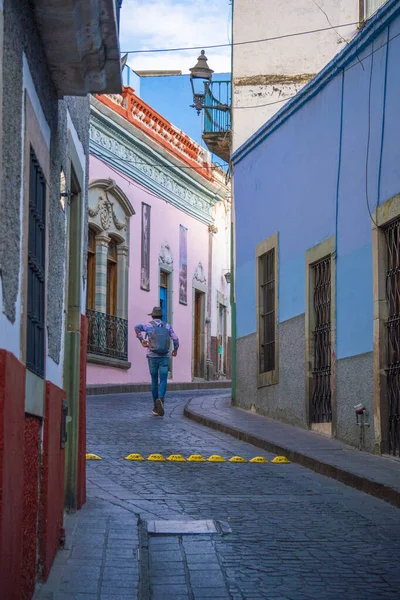 Man is walking by the narrow street with Beautiful Colored Houses in Guanajuato city, Mexico — Stock Photo, Image