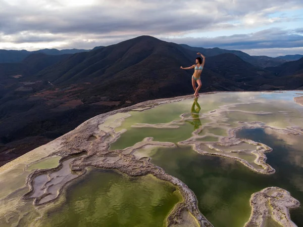 Hava Aracı, Meksika, Oaxaca 'da taşlaşmış şelale Hierve el Agua' nın kenarında dans eden Asyalı kızı vurdu. 4k