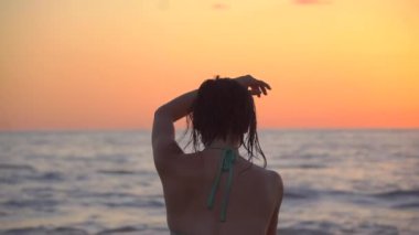 Gün batımında plajda mayo giymiş zarif Asyalı kız dans ediyor. Puerto Escondido 'da okyanus batımı. Yavaş Hareket HD
