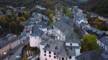 Lüksemburg 'un kuzeyinde CLervaux kasabasının hava aracı vuruldu. Castle ve Cathedral ile Alacakaranlık akşamı sahnesi. 4k, 5k