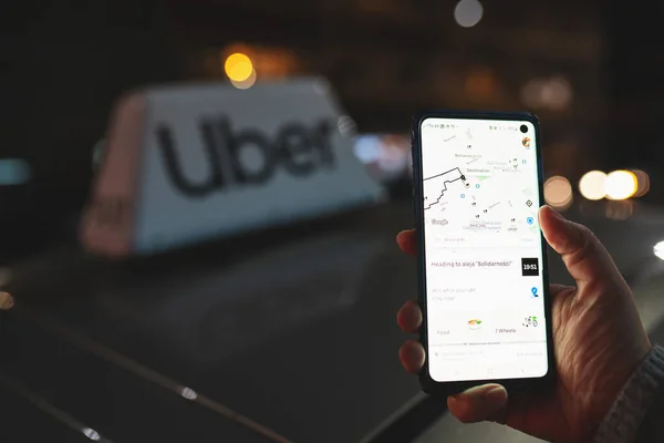 Uber app στο τηλέφωνο με Uber ταξί υπογράψει στο παρασκήνιο — Φωτογραφία Αρχείου