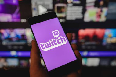 Telefonda Twitch simgesi ile el ele, web sayfası arkaplanı