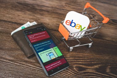 Alışveriş arabasında ebay logosu, uygulamalı akıllı telefon ve cüzdan.