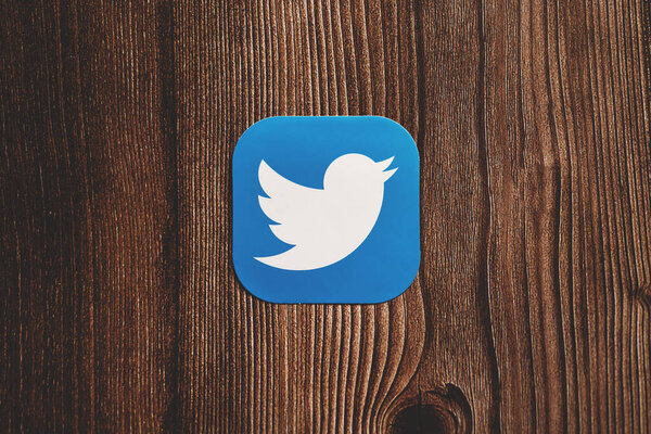 Blue twitter logo on wood background