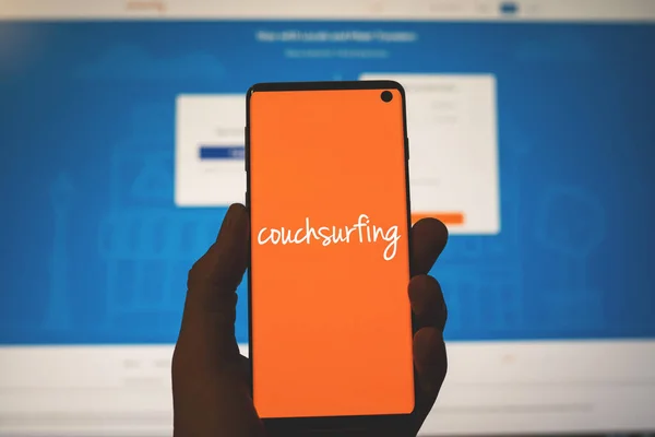 Couchsurfing εικονίδιο στο τηλέφωνο με φόντο την ιστοσελίδα — Φωτογραφία Αρχείου