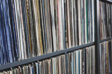 Bir rafta eski renk kapaklarında vinil kayıt koleksiyonu, seçici odaklı kenar görünümü