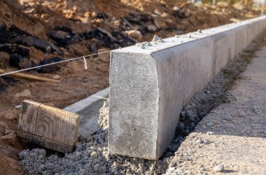 Beton kaldırım döşemesi yol inşaatında çalışıyor. Sicim hattı seviye rehberi. Yakın plan..