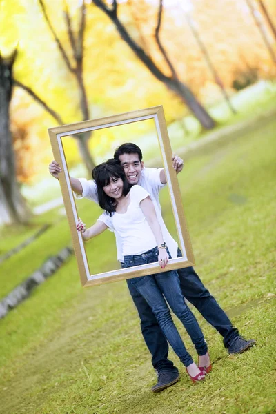 Jeune couple avec cadre en bois — Photo