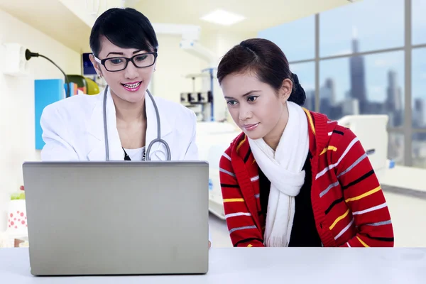 Medico e paziente guardando il computer portatile — Foto Stock