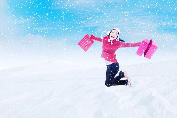 Happy shopper jumping over snowflake — Stock Photo, Image