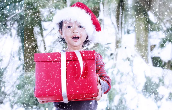 Chica asiática con sombrero de Santa sosteniendo regalos rojos — Foto de Stock