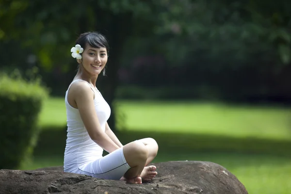 Asiática chica haciendo yoga mirando a cámara —  Fotos de Stock