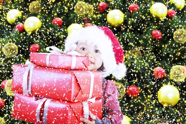 De giften van Kerstmis van meisje onder pijnboom — Stockfoto