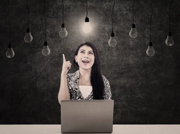 Mujer de negocios con bombillas y portátil — Foto de Stock