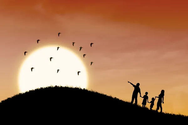Gelukkig familie silhouet met zonsondergang landschap — Stockfoto