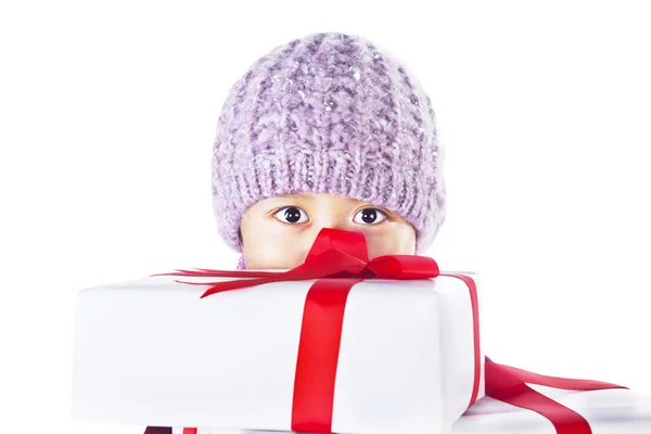 Boy hiding behind Christmas gifts isolated in white — Stock Photo, Image