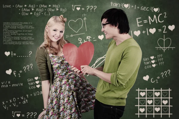 Cute nerd guy and girl giving love in class — Stock Photo, Image