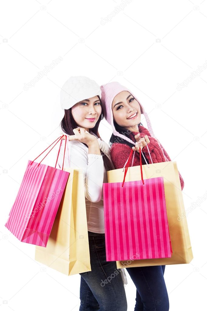 Friends shop together holding bags isolated in white