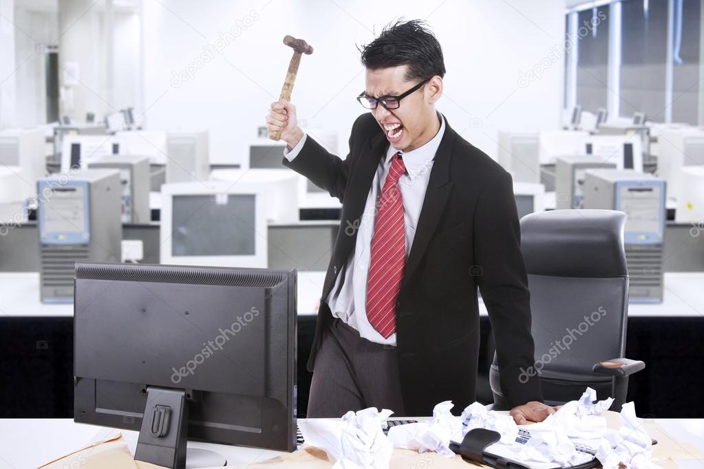 Angry businessman throw hammer at computer — Stock Photo © realinemedia