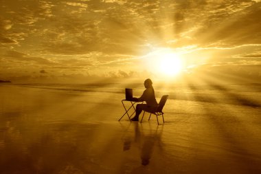 Girl-with-laptop-at-Sunset-on-the-Beach