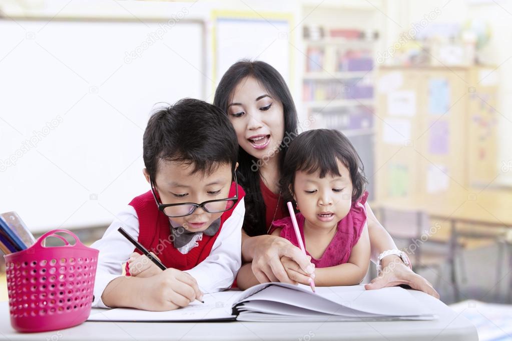 Teacher and children study in classroom