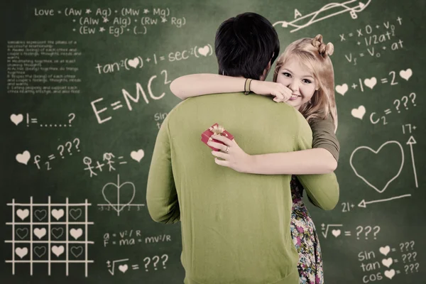 Happy couple hugging in class — Stock Photo, Image