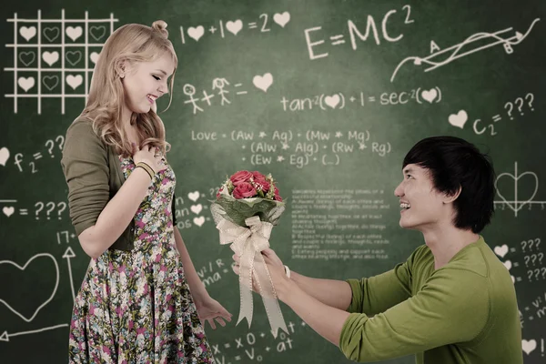 Hermosa chica nerd obtener flores en clase — Foto de Stock