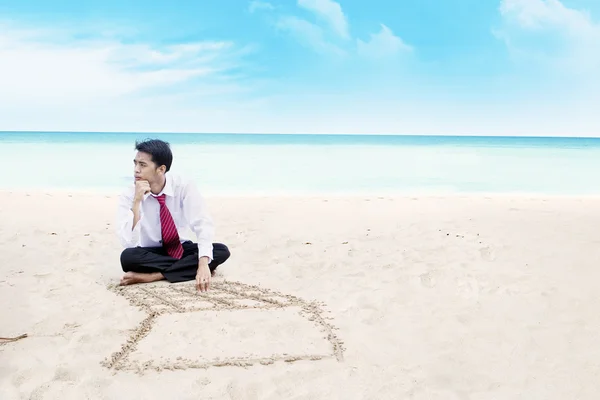 Zakenman denken op een strand — Stockfoto