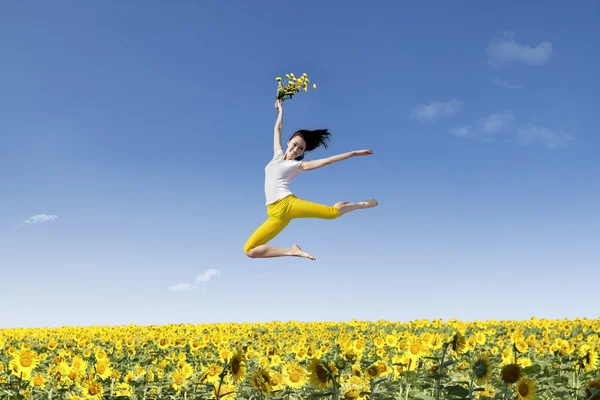 Menina dança sobre girassóis amarelos — Fotografia de Stock