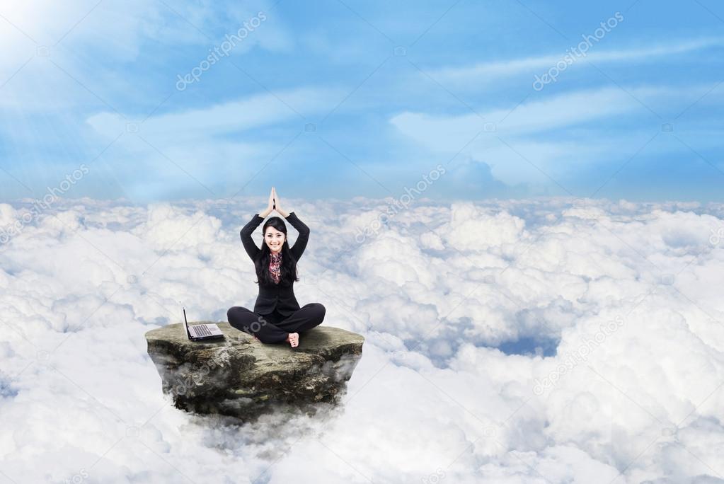 Businesswoman working above clouds