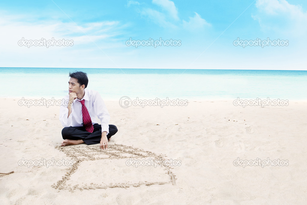 Businessman thinking on a beach