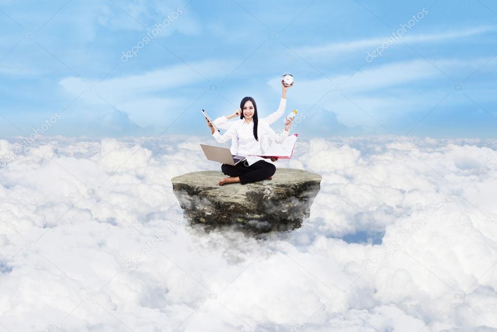 Beautiful woman multitasking above clouds